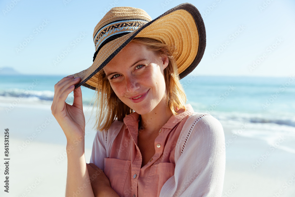 Portrait of woman wearing hat smiling on the beach