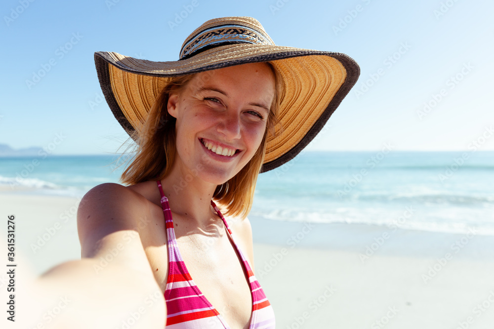 Portrait of woman wearing hat smiling on the beach
