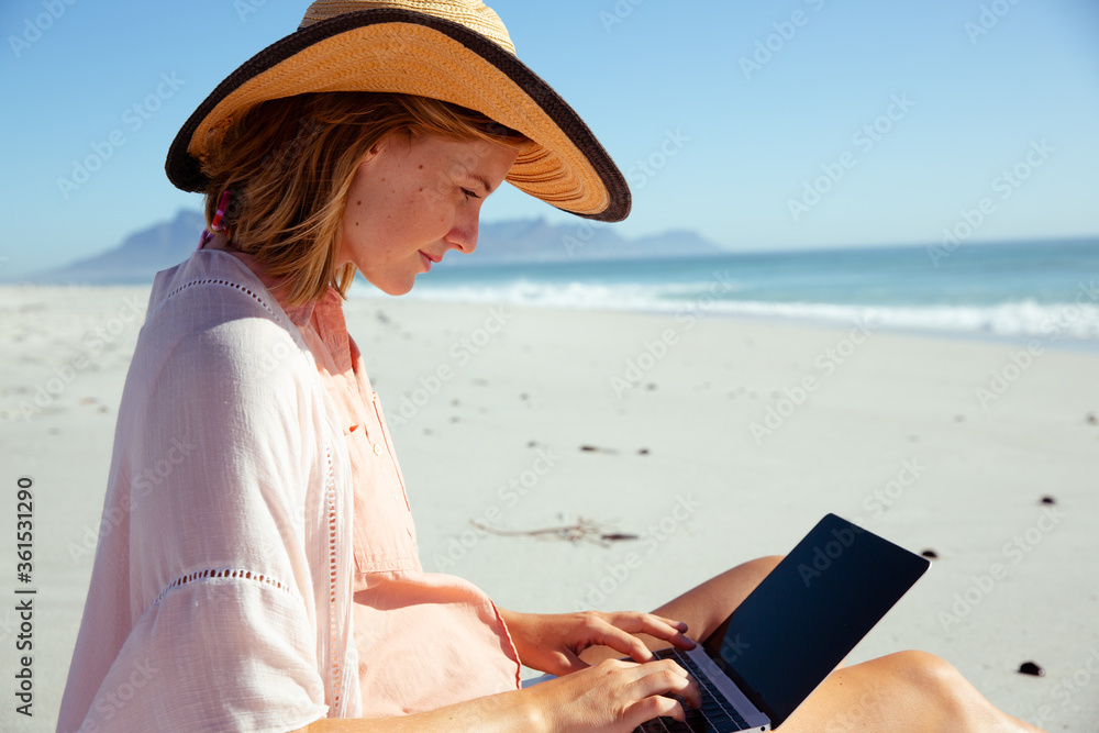 Woman using laptop at the beach