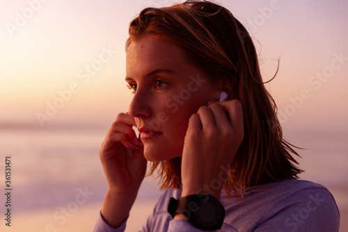 Beautiful woman wearing earphones on the beach