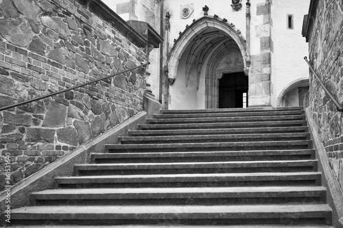 Moody black and white stairs and entrace to St. Vitus church in Cesky Krumlov without people during lockdown