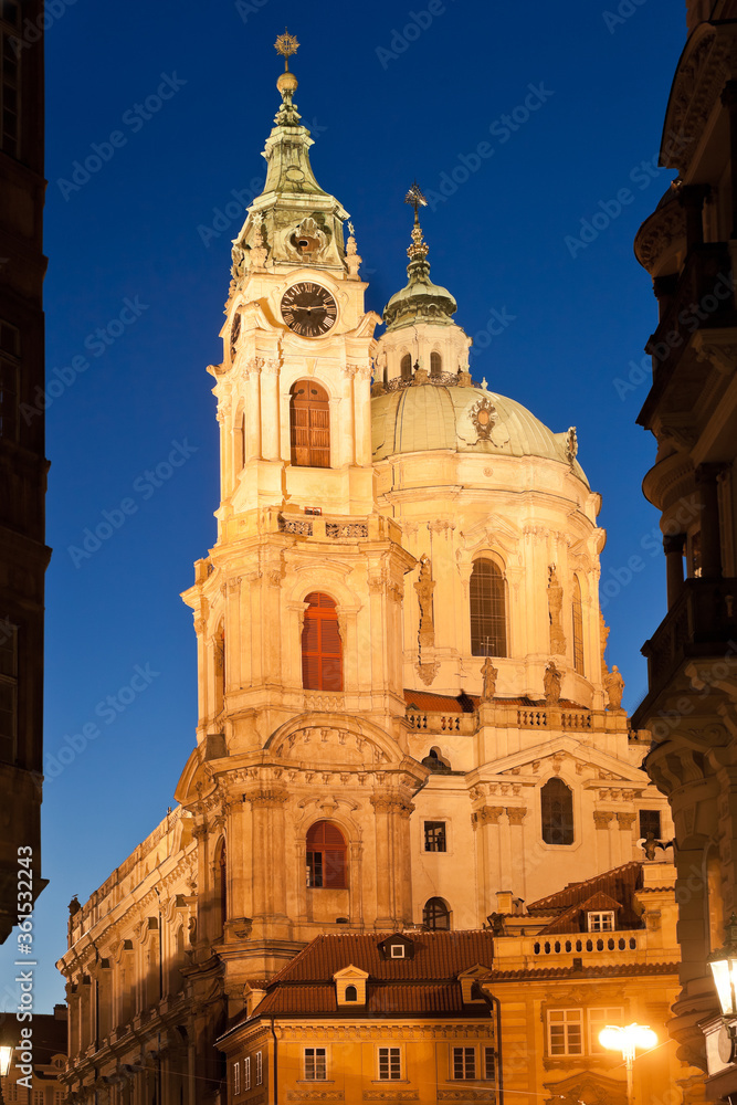 Illuminated St. Nicholas church in Lesser town of Prague during twilight