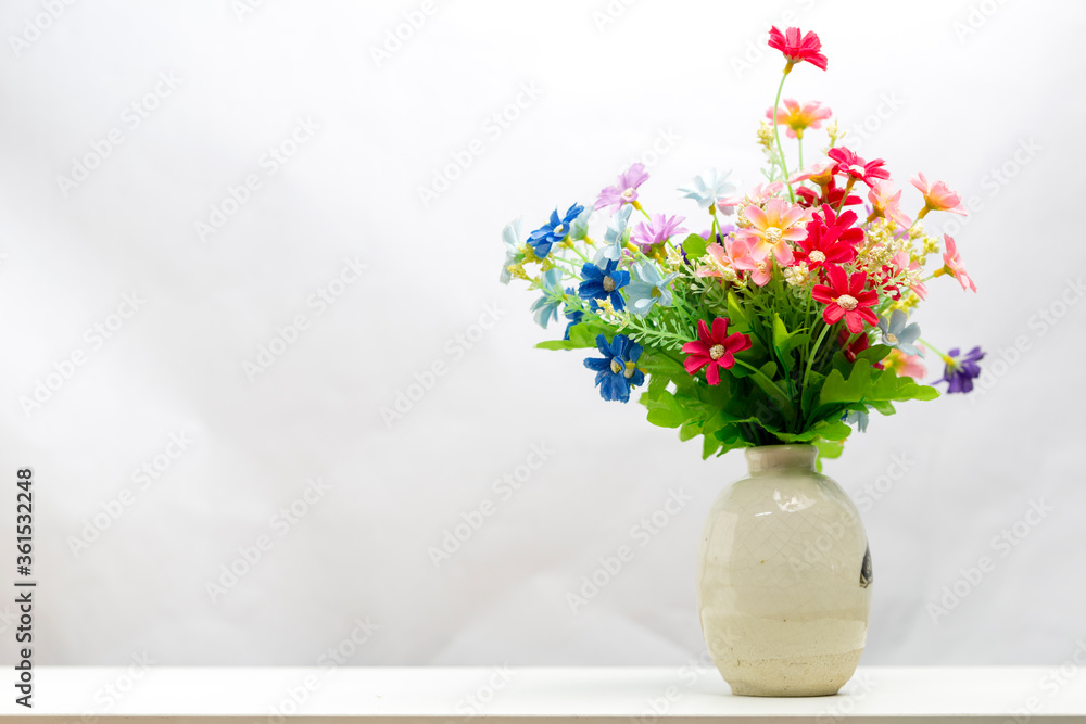 bunch of plastic flowers in vase