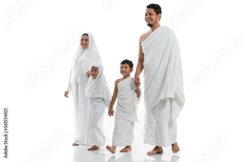muslim hajj family and children walking and hold hand isolated over white background photo