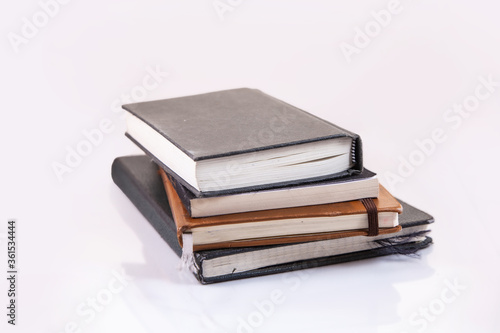 Old Used Notebooks and Sketchbooks arranged and isolated on a white background