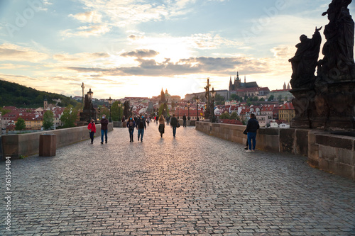 Locals casually walking down Charles bridge and enjoying the relaxed atmosphere during a lockdown in Prague