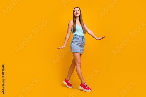 Full length body size view of her she nice-looking attractive lovely cheerful cheery straight-haired girl going enjoying summertime isolated over bright vivid shine vibrant yellow color background © deagreez