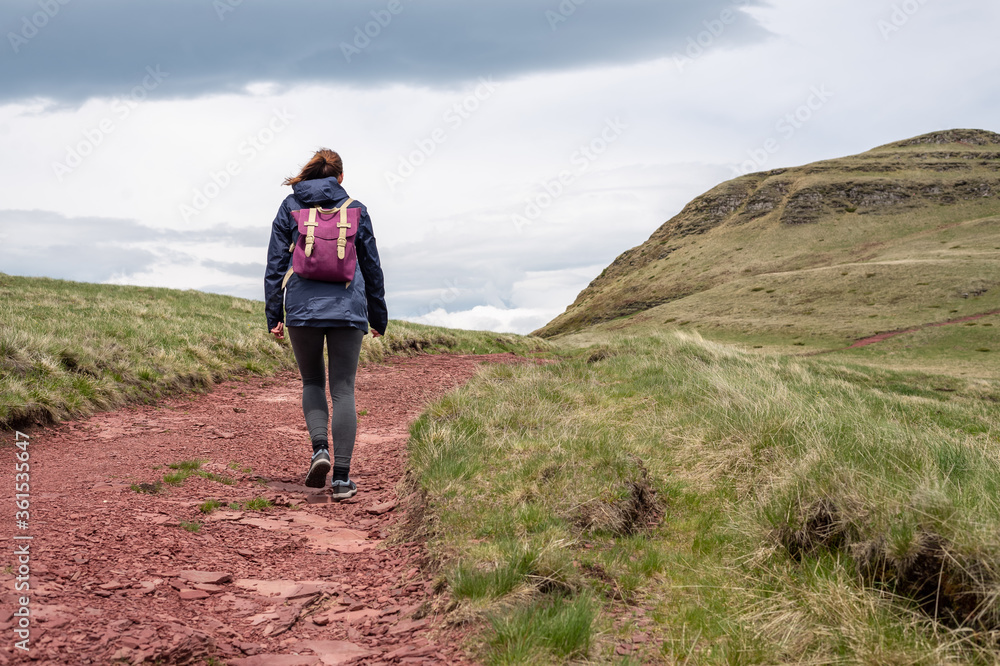 Woman with backpack hiking in mountain