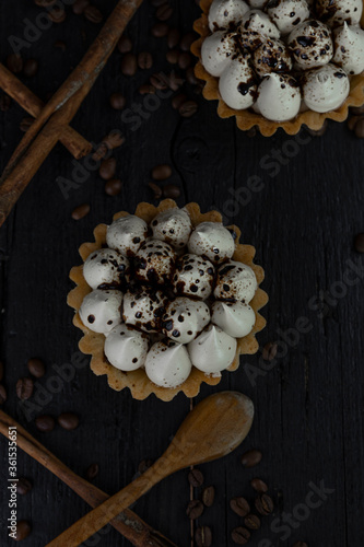 Cappuccino tart with cinnamon sticks and coffee beans on rustic wooden table