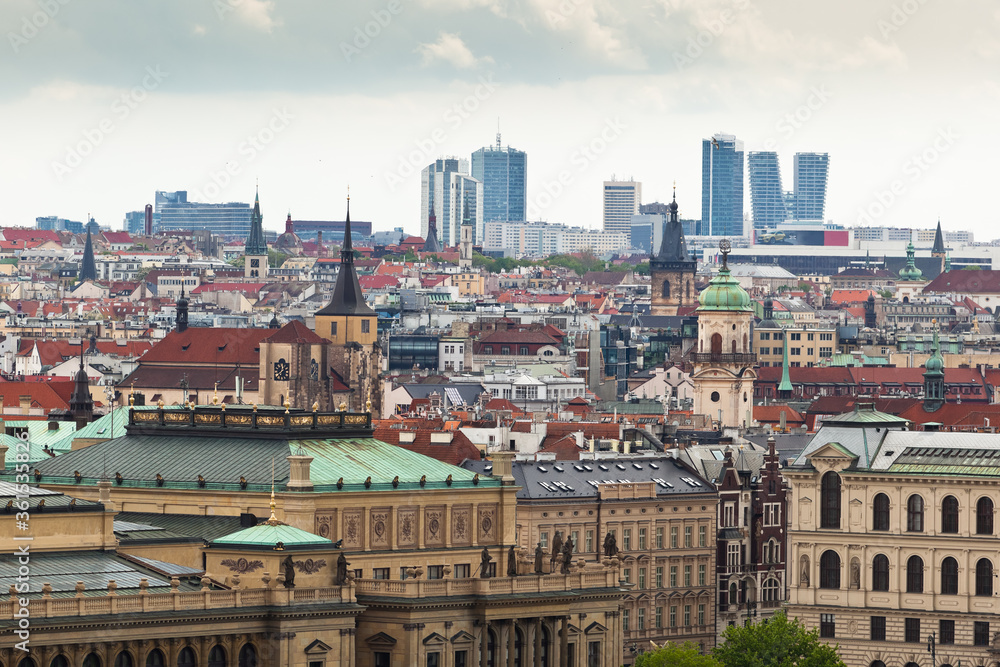 Aerial view of contrast between Old town of Prague with its many towers and red roofs in the foreground and the new business skyline in the background