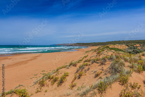 Landscape at Wattpinga Beach in the Newland Head Conservation Park in South Australia with view of the beach and mountain slope with native plants and shrubs.