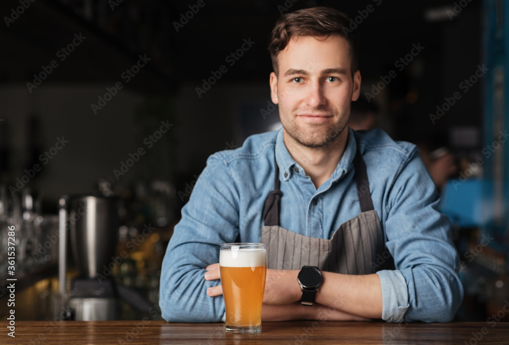 Friday at pub with drinks. Handsome barman at bar counter with bartender tools Friday at pub with drinks. Handsome barman at bar counter with bartender tools