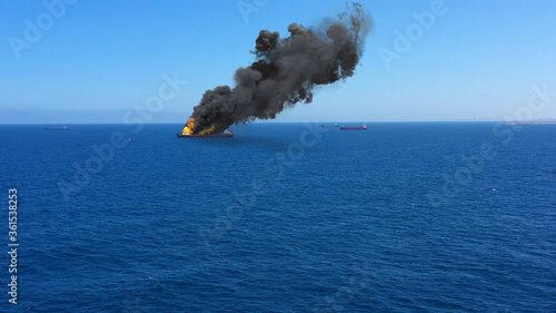 Cargo ship burning on fire with large scale smoke-Aerial
Aerial, Mediterranean Sea, Cargo tanker ship, Real Drone view with visual effect Elements 
