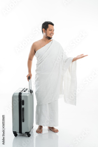 asian male with ihram presenting copyspace. hajj and umrah man concept photo