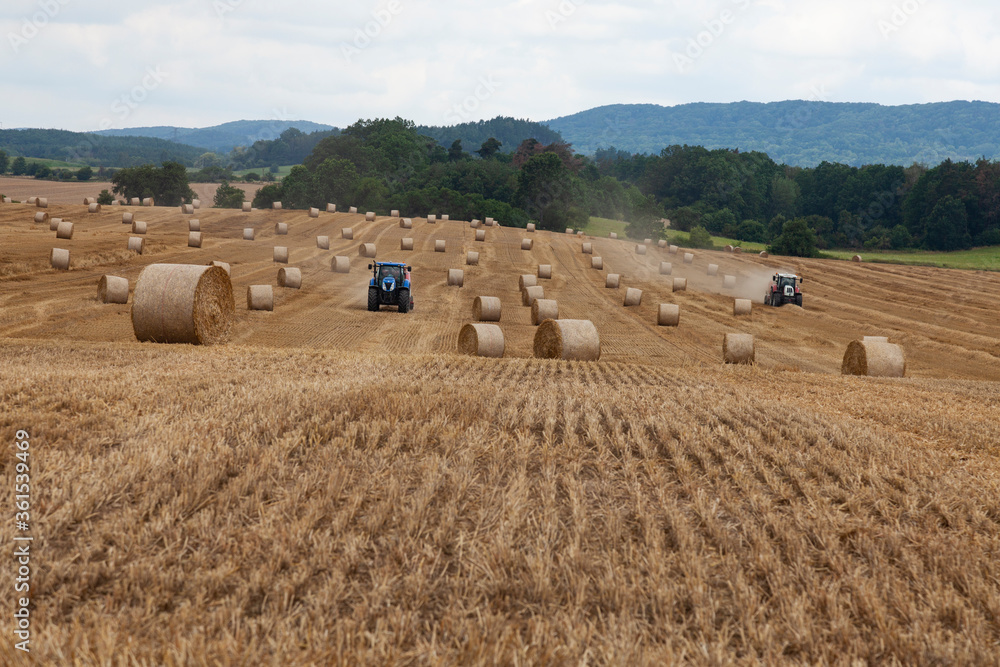 traktor making hay bales in a field - hay bale making machine