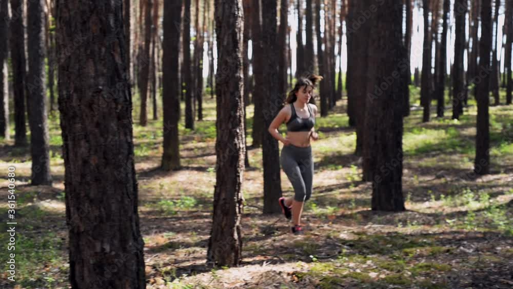 Athletic and active young girl runs on a morning forest trail, healthy lifestyle. Connection with nature. Athletic and active young girl runs on a morning forest trail, healthy lifestyle. Connection with nature.