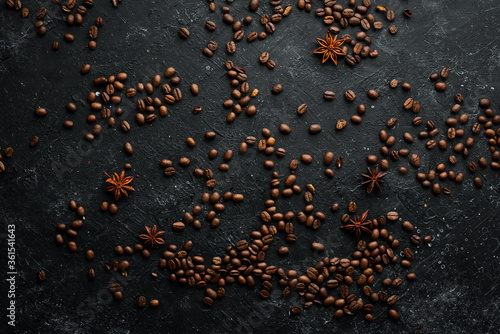 Roasted fragrant coffee beans on a black stone background. Top view. Free space for your text.