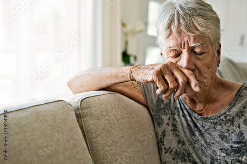 Portrait Of crying Senior Woman On Sofa Suffering From Depression