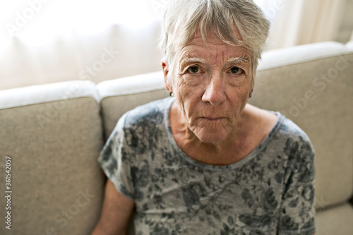 Portrait Of Senior Woman On Sofa Suffering From Depression