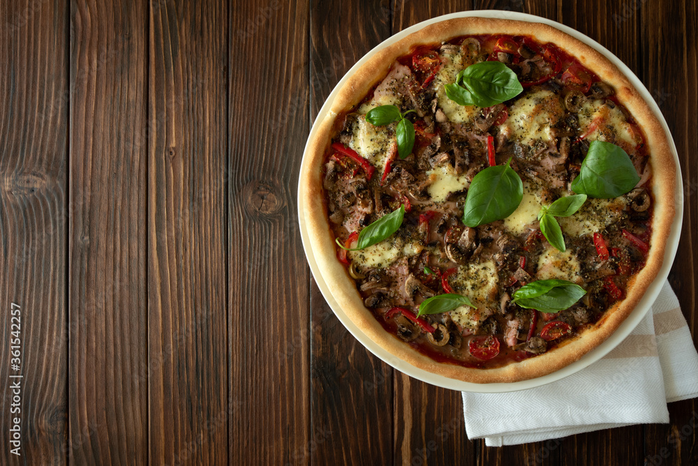 Delicious italian pizza on brown wooden background. Copy space. Top view Delicious italian pizza on brown wooden background. Copy space. Top view