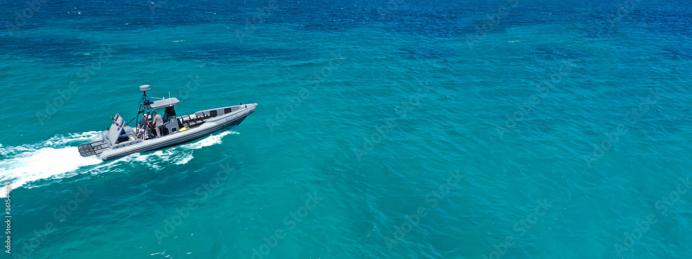 Naklejka premium Aerial drone ultra wide photo of rigid inflatable speed boat cruising in deep blue Aegean sea, Greece