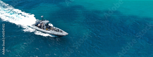 Aerial drone ultra wide photo of rigid inflatable speed boat cruising in deep blue Aegean sea, Greece