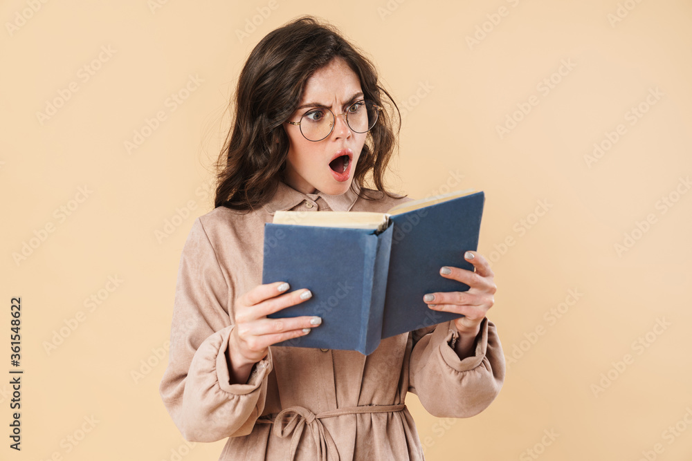 Image of shocked caucasian woman in eyeglasses reading book Image of shocked caucasian woman in eyeglasses reading book