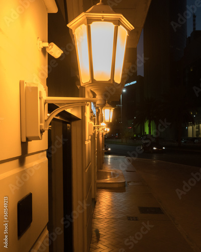 Vintage metallic lanterns hanging on the wall on the street at night