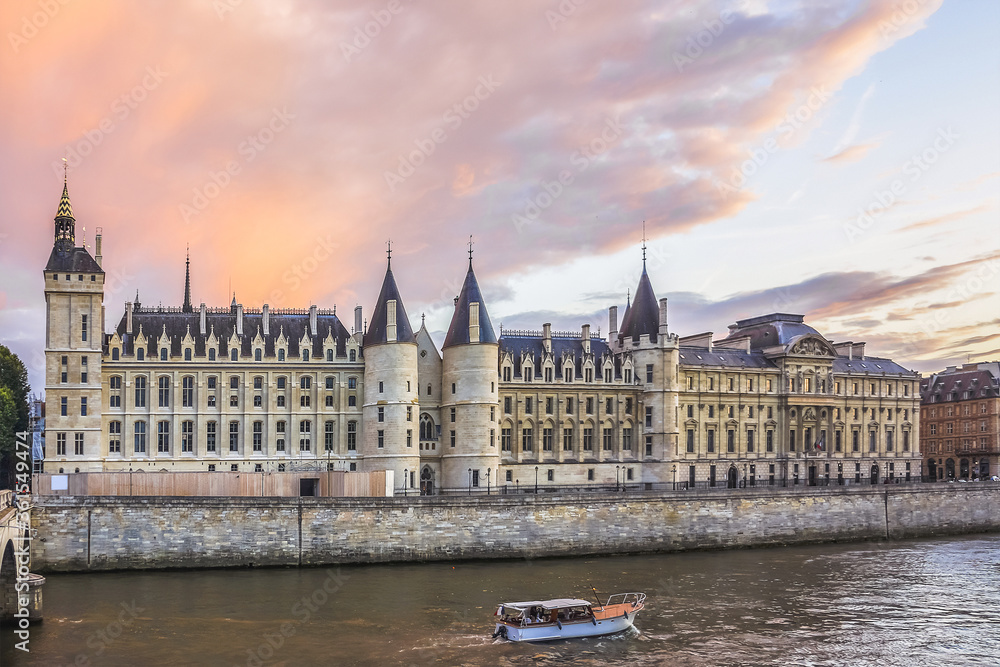 Castle Conciergerie - former royal palace and prison. Conciergerie located on the west of the Cite Island and today it is part of larger complex known as Palais de Justice. Paris, France. Sunset.