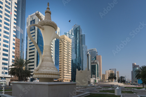 Abu Dhabi/United Arab Emirates - August 2019: Al Ittihad Square with a traditional coffee pot on the foreground and tall buildings around it