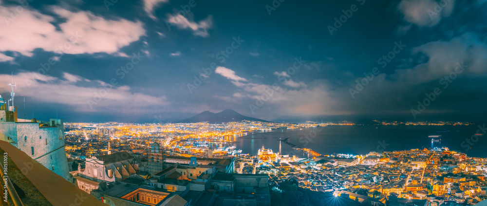 Naples, Italy. Skyline Cityscape In Evening Lighting. Tyrrhenian Sea And Landscape With Volcano Mount Vesuvius. City In Night Illuminations