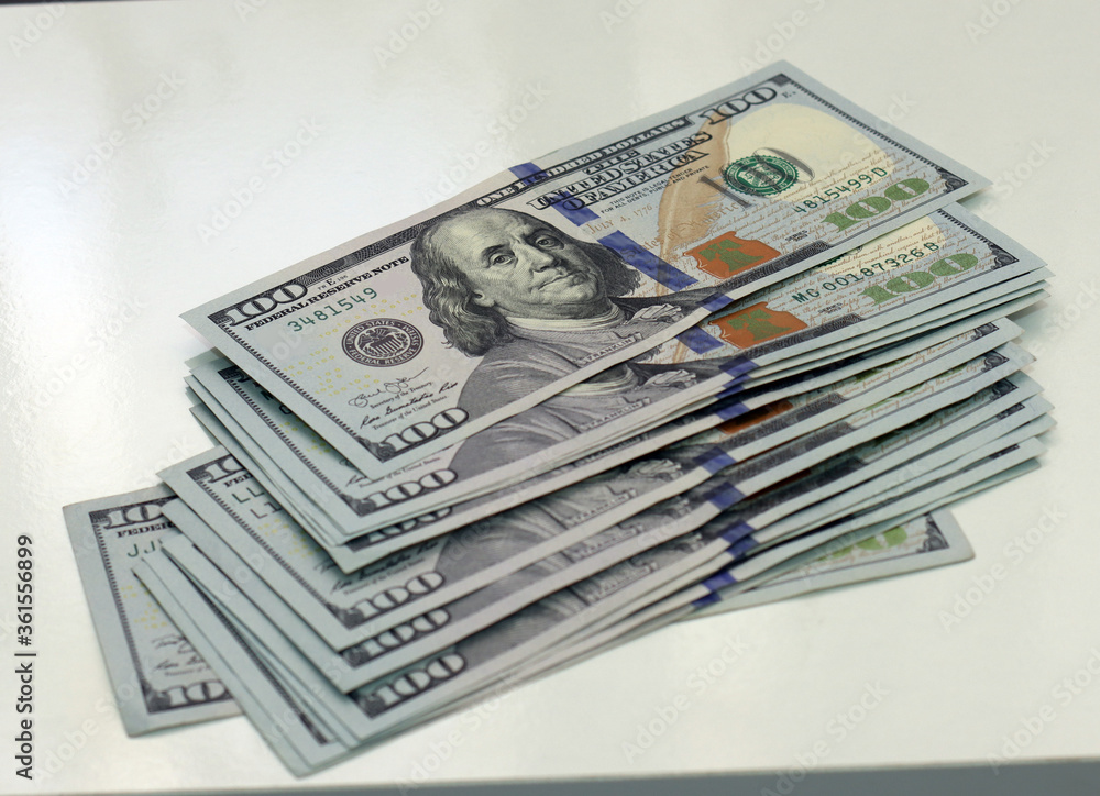Cash of hundred dollar bills. A pile of one hundred US banknotes .100 Dollar. Cash of hundred dollar bills. A pile of one hundred US banknotes .100 Dollar.