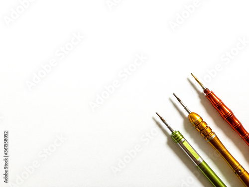 Three colored screwdrivers on a white background. Screwdrivers isolated with copy space. Small screwdrivers for fix mobiles. 