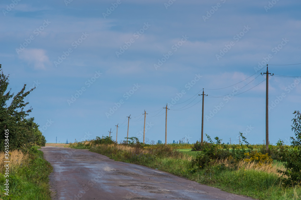 Rural road passing along the electric poles Rural road passing along the electric poles