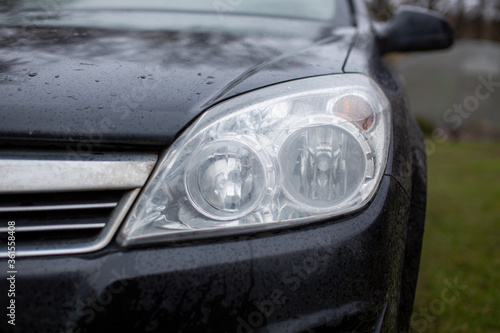 headlight of a car on a background of greenery