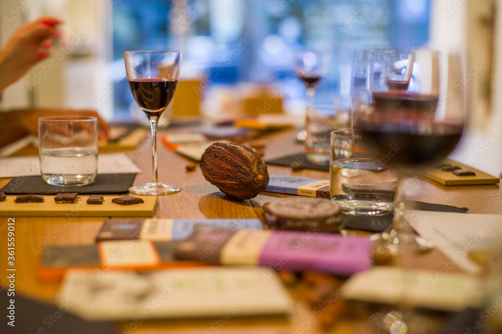 Dark chocolate tasting with wine. Cocoa beans on the table with glasses of red wine Dark chocolate tasting with wine. Cocoa beans on the table with glasses of red wine