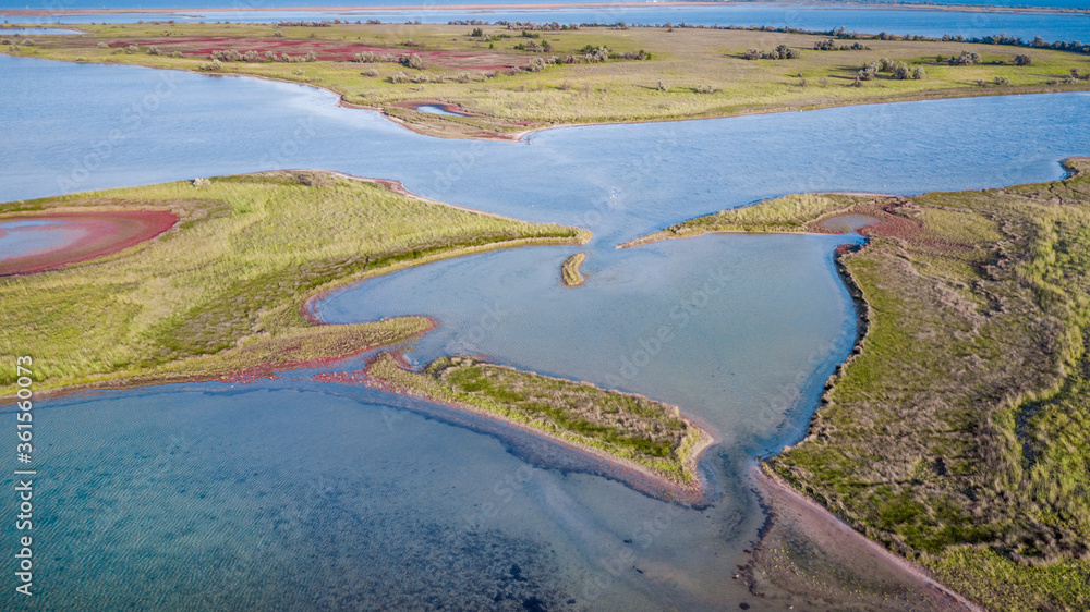 amazing aerial view of blue and pink lakes, sea on horizon. Beautiful natural landscape. Drone shot, bird's eye.