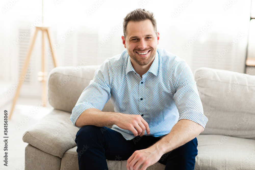 Happy man having rest at home on the sofa
