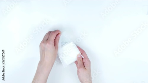 The girl pulls out of the package sanitary pad