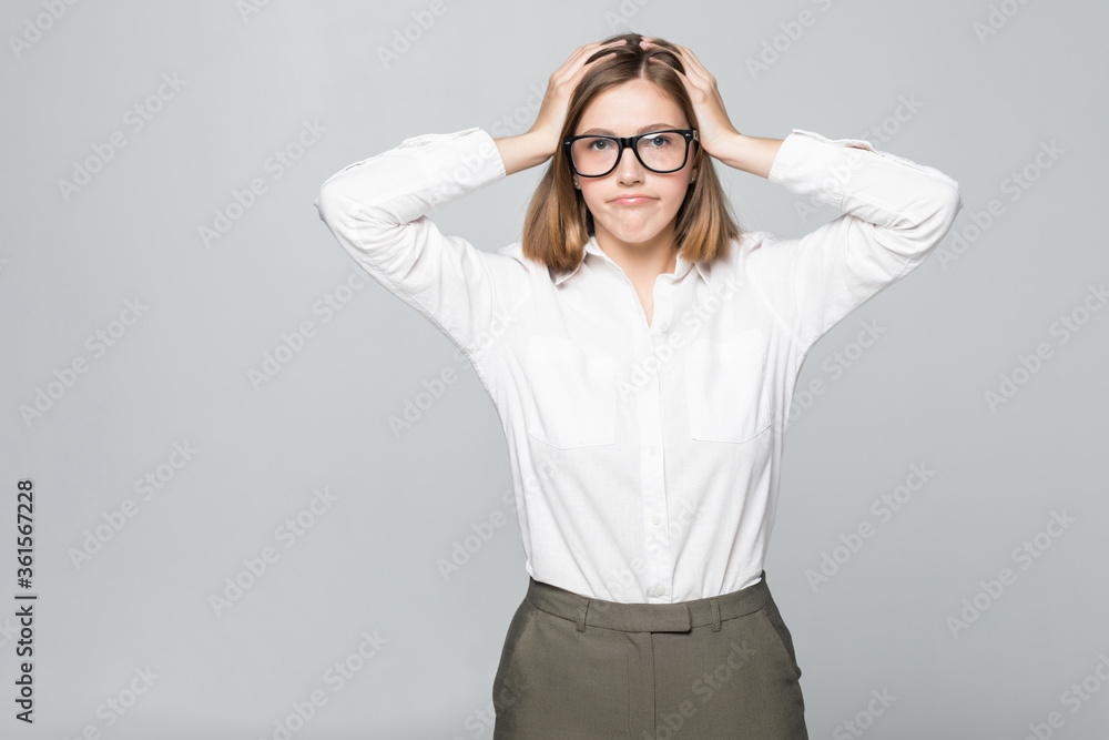 Portrait of unhappy young businesswoman holding hands in head isolated on white background