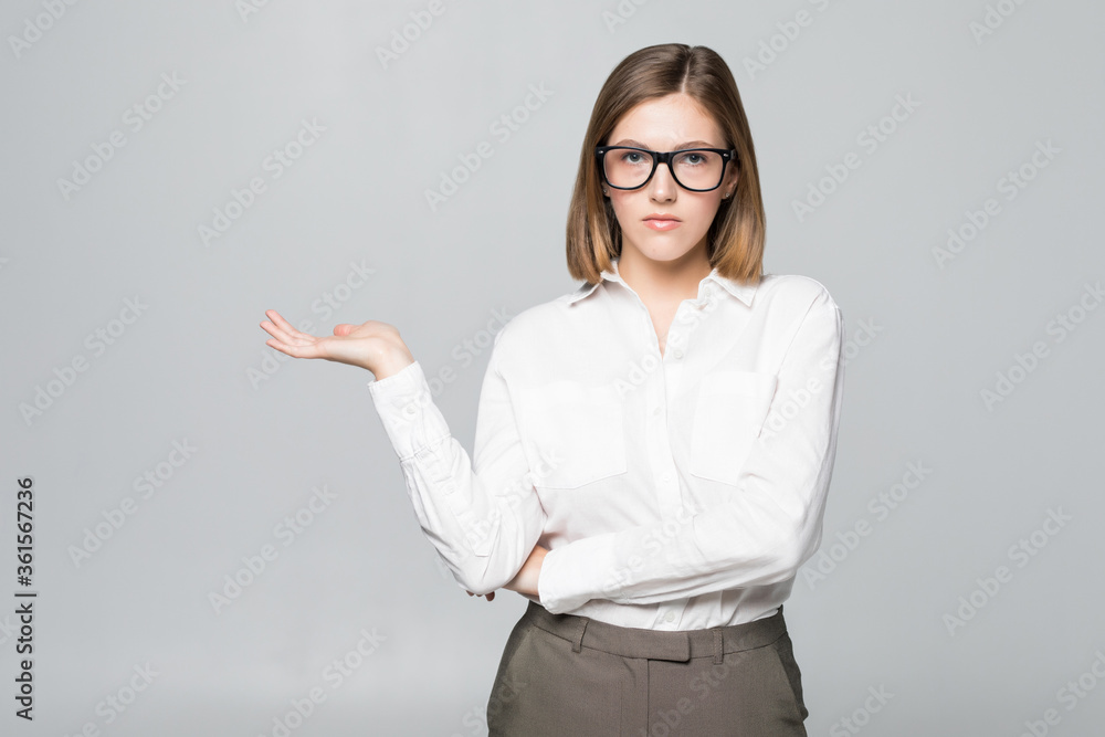 Businesswoman showing copy space for product with open hand palm. Smiling friendly expression on young businesswoman wearing glasses isolated on white background. Businesswoman showing copy space for product with open hand palm. Smiling friendly expression on young businesswoman wearing glasses isolated on white background.