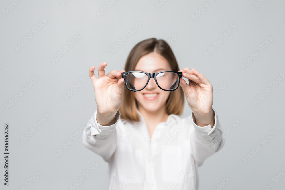 Glasses optician showing eyewear. Closeup of glasses, with glasses and frame in focus. Woman optometrist on white background.