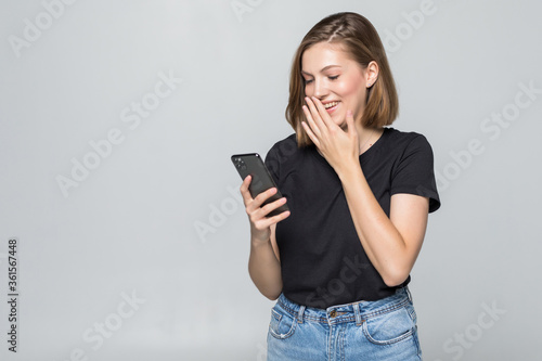 Young woman texting on her mobile phone over a white background