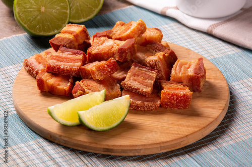 Fotografía Deep fried crispy pork belly served with two half lemon on the table