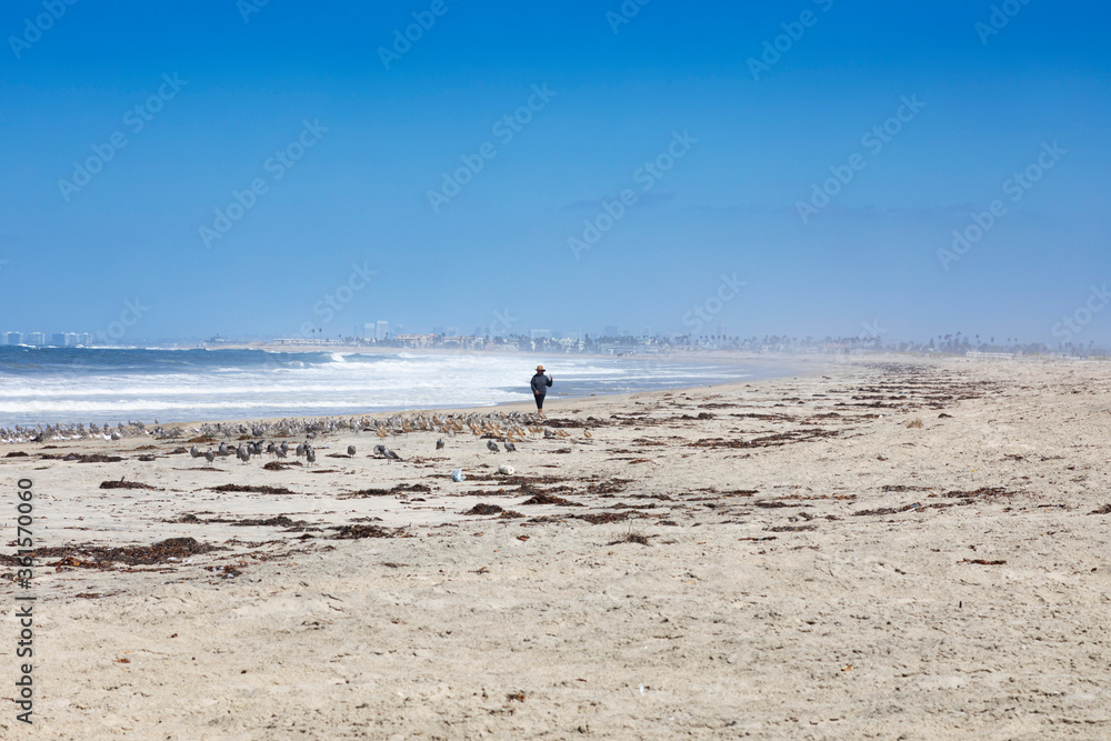 A lone woman walk in a empty beach close to International Friendship park, the border between USA and Mexico