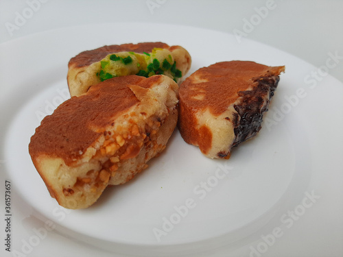 Pukis, is an Indonesian traditional pancake, with various toppings. On white plate. Isolated in white background. photo