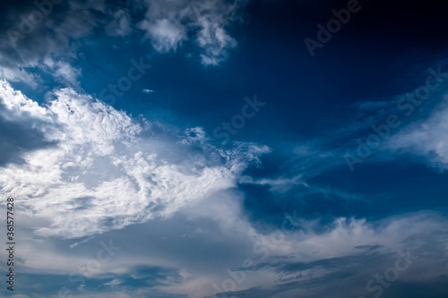 Blue and white cloudy sky after the thunderstorm including cirrus and cumulus clouds with sunlight. 