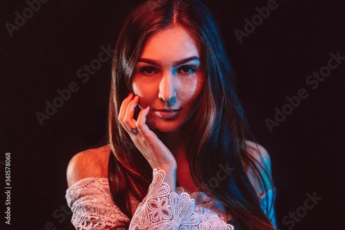 Junge frau Portrait vor schwarzem Hintergrund mit roten und blauen Lichtern