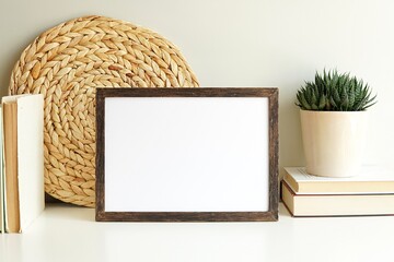 Boho style empty photo frame, dark wood frame mockup, horizontal wooden sign mock-up for artwork, bohemian interior, books, plant on white shelf.