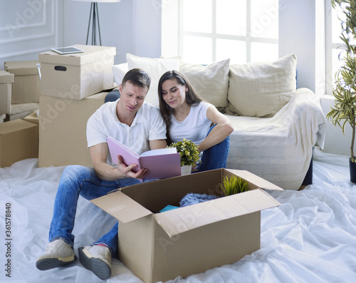 Cute couple unpacking cardboard boxes in their new home